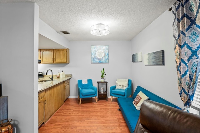 802 Antler Ct, Brandon, FL 33511 - sitting room with light wood finished floors, a textured ceiling, and baseboards