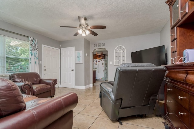 1403 W Pradera Ave, Tampa, FL 33612 - living room featuring a ceiling fan, light tile patterned flooring, a textured ceiling, and baseboards