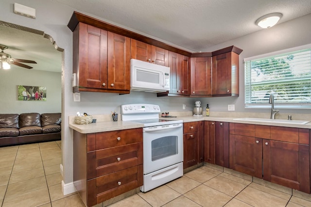 1403 W Pradera Ave, Tampa, FL 33612 - kitchen featuring white appliances, a sink, light countertops, light tile patterned floors, and a ceiling fan