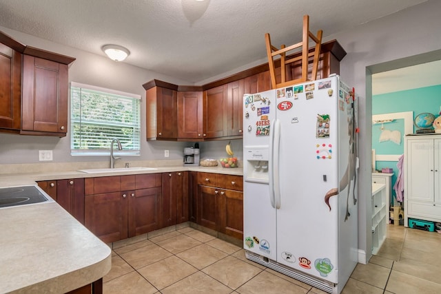 1403 W Pradera Ave, Tampa, FL 33612 - kitchen featuring white fridge with ice dispenser, light tile patterned flooring, a sink, light countertops, and a textured ceiling