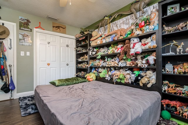1403 W Pradera Ave, Tampa, FL 33612 - bedroom featuring dark wood-style floors, a textured ceiling, baseboards, a ceiling fan, and a closet
