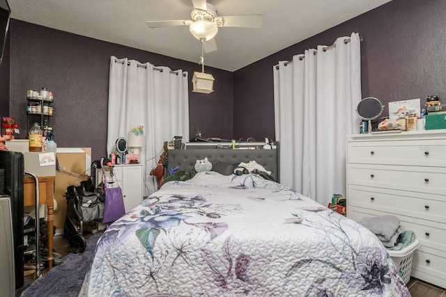 1403 W Pradera Ave, Tampa, FL 33612 - bedroom featuring a textured wall, a ceiling fan, and wood finished floors