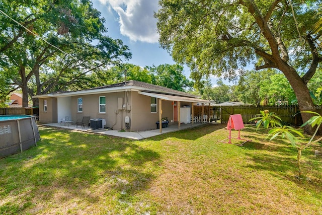 1403 W Pradera Ave, Tampa, FL 33612 - rear view of property with central air condition unit, stucco siding, and a patio