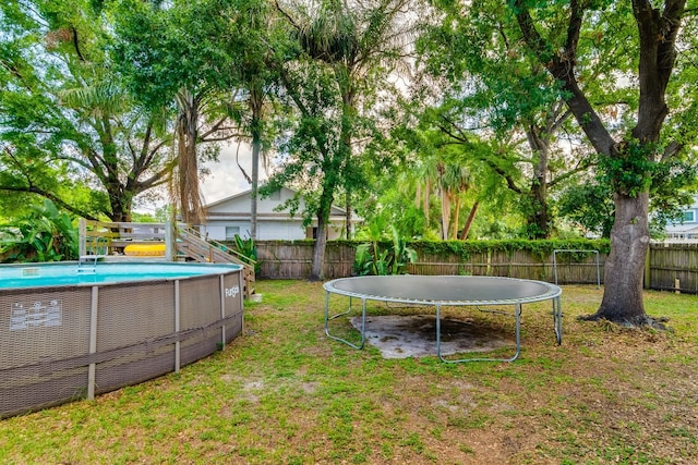 1403 W Pradera Ave, Tampa, FL 33612 - view of yard featuring a trampoline and an outdoor pool
