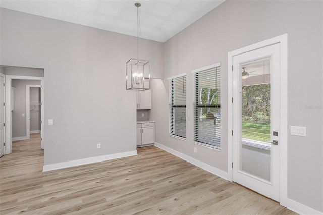 17404 Nokota Ave, Hudson, FL 34667 - unfurnished dining area with light wood finished floors, baseboards, and a chandelier