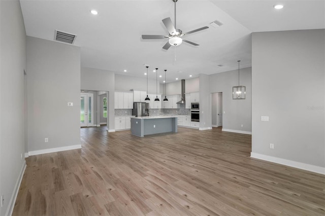 17404 Nokota Ave, Hudson, FL 34667 - unfurnished living room with ceiling fan, light wood-style floors, baseboards, recessed lighting, and a chandelier
