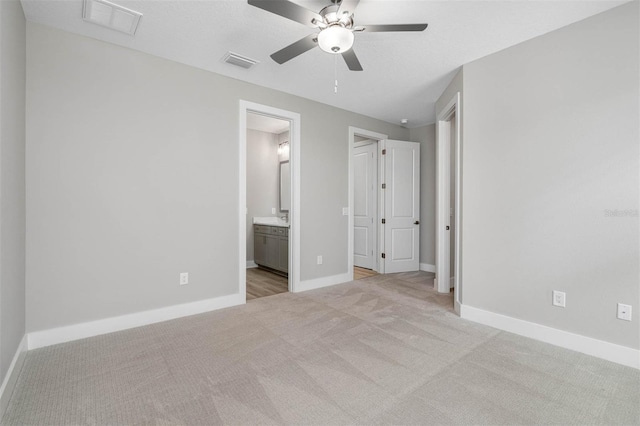 17404 Nokota Ave, Hudson, FL 34667 - unfurnished bedroom with carpet, baseboards, ensuite bathroom, and a ceiling fan