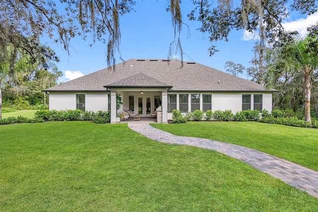 13167 Oldenburg Dr, Hudson, FL 34667 - rear view of property with french doors, a lawn, a shingled roof, and stucco siding