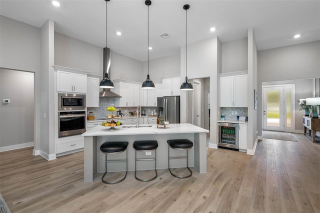 13167 Oldenburg Dr, Hudson, FL 34667 - kitchen with stainless steel appliances, a sink, wine cooler, high vaulted ceiling, and light countertops