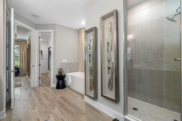13167 Oldenburg Dr, Hudson, FL 34667 - full bath with a shower stall, a bath, wood finished floors, and baseboards