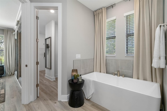13167 Oldenburg Dr, Hudson, FL 34667 - full bath with a freestanding tub, wood finished floors, and baseboards