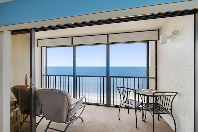 14950 Gulf Blvd Unit 905, Madeira Beach, FL 33708 - sunroom / solarium featuring a textured wall, view of water and beach, and carpet floors