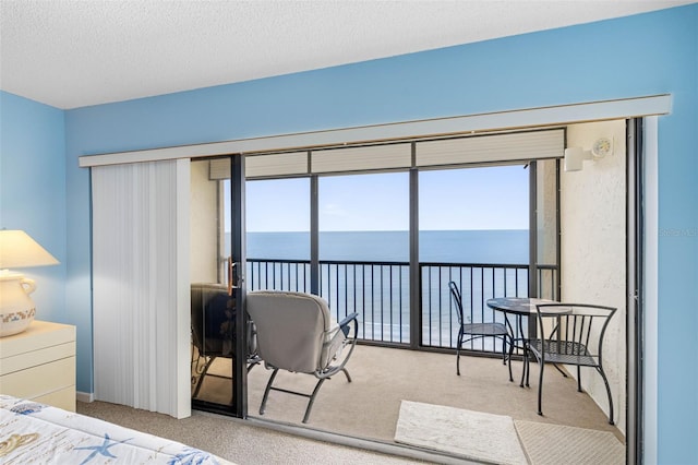 14950 Gulf Blvd Unit 905, Madeira Beach, FL 33708 - bedroom featuring a water view, carpet, access to exterior, and a textured ceiling