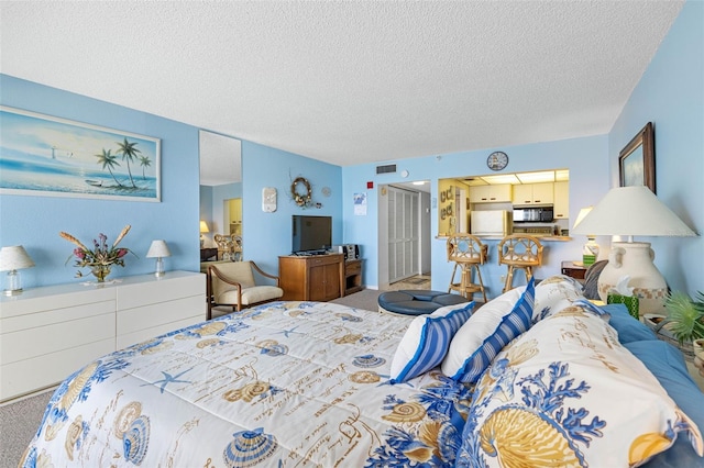 14950 Gulf Blvd Unit 905, Madeira Beach, FL 33708 - bedroom with carpet, a textured ceiling, freestanding refrigerator, and a closet