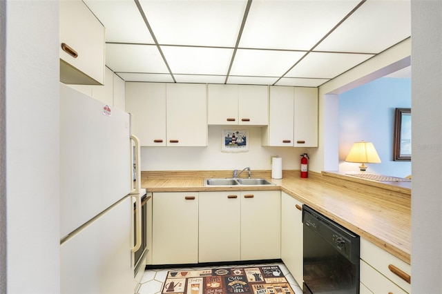 14950 Gulf Blvd Unit 905, Madeira Beach, FL 33708 - kitchen with dishwasher, a sink, freestanding refrigerator, a paneled ceiling, and white cabinets