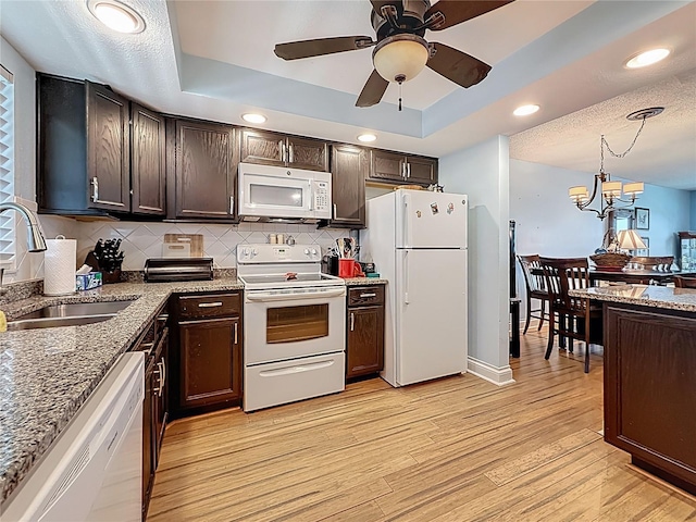 4725 Cove Cir Unit 908, Saint Petersburg, FL 33708 - kitchen featuring white appliances, a tray ceiling, a sink, dark brown cabinetry, and recessed lighting