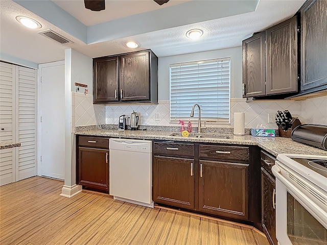 4725 Cove Cir Unit 908, Saint Petersburg, FL 33708 - kitchen featuring white appliances, a sink, dark brown cabinetry, light wood finished floors, and tasteful backsplash