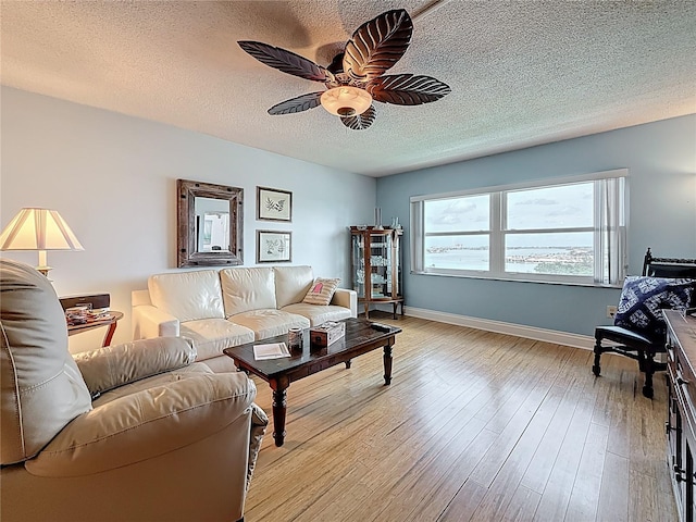 4725 Cove Cir Unit 908, Saint Petersburg, FL 33708 - living area featuring ceiling fan, a textured ceiling, light wood-style floors, and baseboards