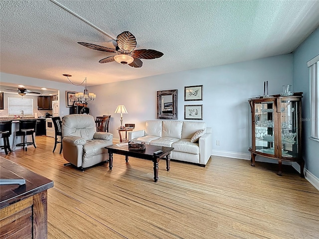 4725 Cove Cir Unit 908, Saint Petersburg, FL 33708 - living area featuring ceiling fan, light wood-style floors, a textured ceiling, and baseboards