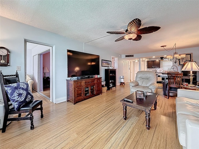 4725 Cove Cir Unit 908, Saint Petersburg, FL 33708 - living room with a ceiling fan, light wood-type flooring, a textured ceiling, and a chandelier