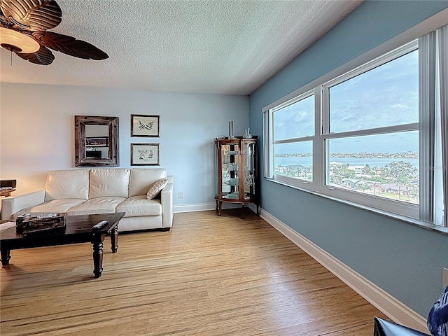 4725 Cove Cir Unit 908, Saint Petersburg, FL 33708 - living room featuring light wood finished floors, a textured ceiling, ceiling fan, and baseboards