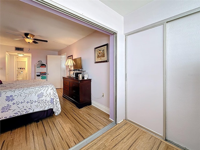 4725 Cove Cir Unit 908, Saint Petersburg, FL 33708 - bedroom with light wood finished floors, a closet, baseboards, and a ceiling fan