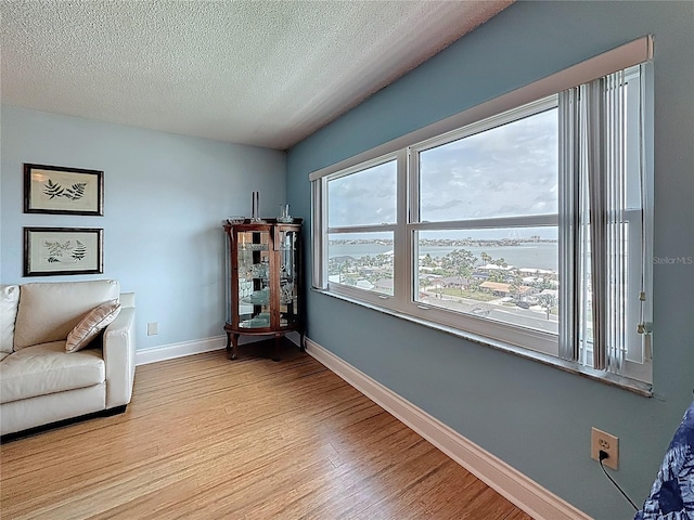 4725 Cove Cir Unit 908, Saint Petersburg, FL 33708 - living area featuring light wood-style floors, baseboards, and a textured ceiling