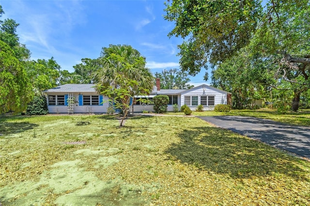 601 75th St N, Saint Petersburg, FL 33710 - single story home featuring a chimney, asphalt driveway, and a front lawn