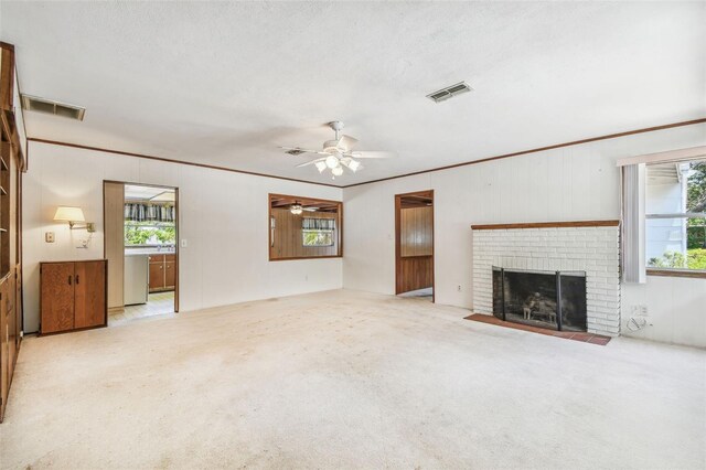 601 75th St N, Saint Petersburg, FL 33710 - unfurnished living room featuring plenty of natural light, carpet, a brick fireplace, ceiling fan, and ornamental molding