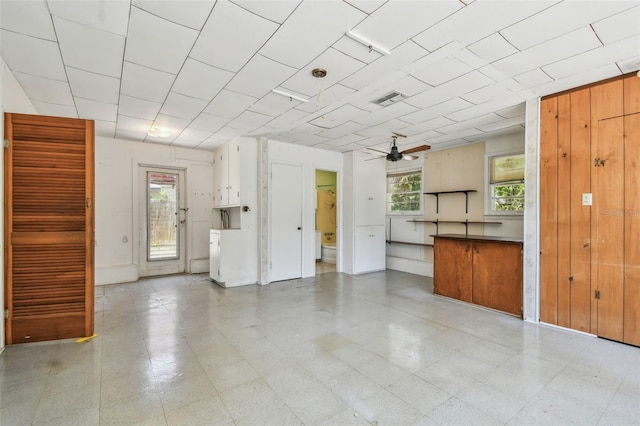 601 75th St N, Saint Petersburg, FL 33710 - unfurnished living room featuring ceiling fan and wooden walls