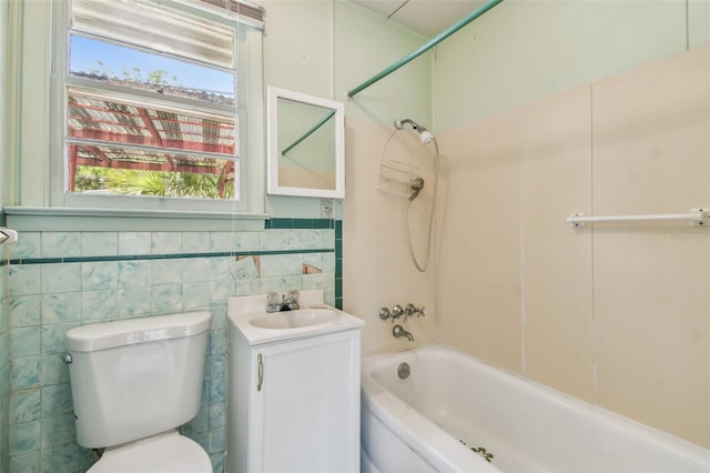 601 75th St N, Saint Petersburg, FL 33710 - full bath featuring toilet, shower / bathtub combination, vanity, tile walls, and a wainscoted wall
