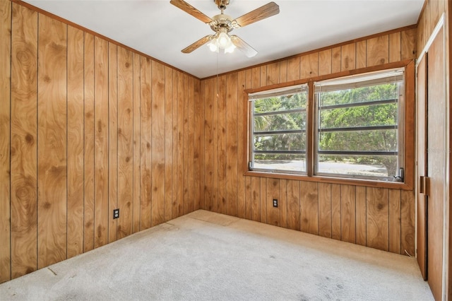 601 75th St N, Saint Petersburg, FL 33710 - carpeted empty room featuring wood walls and ceiling fan