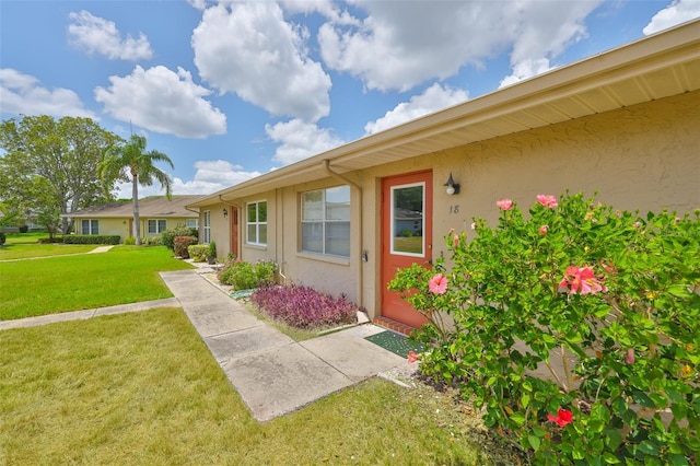1904 Canterbury Ln Unit 18, Sun City Center, FL 33573 - property entrance featuring stucco siding and a lawn