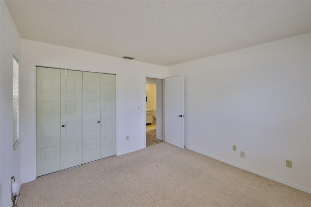 1904 Canterbury Ln Unit 18, Sun City Center, FL 33573 - unfurnished bedroom with carpet floors, a closet, a textured ceiling, and baseboards