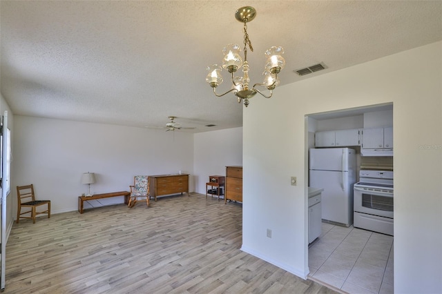 1904 Canterbury Ln Unit 18, Sun City Center, FL 33573 - kitchen featuring white appliances, under cabinet range hood, light wood-type flooring, ceiling fan, and a textured ceiling
