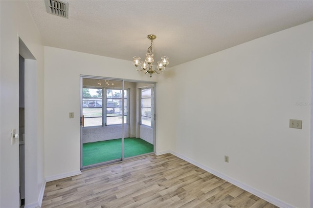 1904 Canterbury Ln Unit 18, Sun City Center, FL 33573 - spare room with wood finished floors, a chandelier, and baseboards