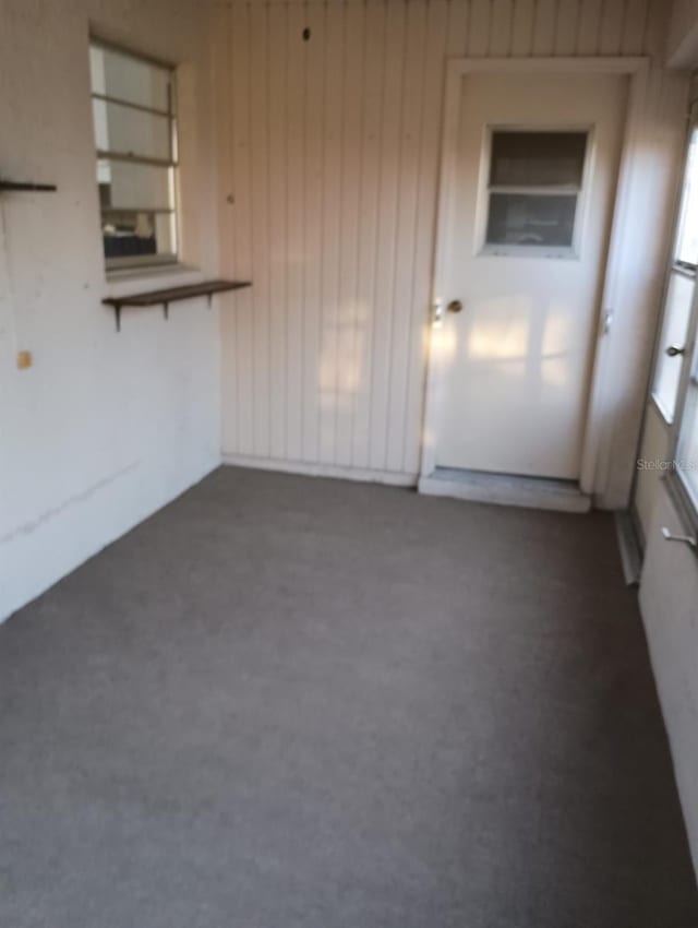 1904 Canterbury Ln Unit 18, Sun City Center, FL 33573 - unfurnished living room with dark carpet and wood walls