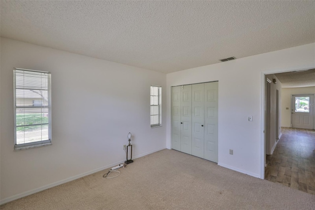 1904 Canterbury Ln Unit 18, Sun City Center, FL 33573 - unfurnished bedroom featuring carpet, a textured ceiling, a closet, and baseboards