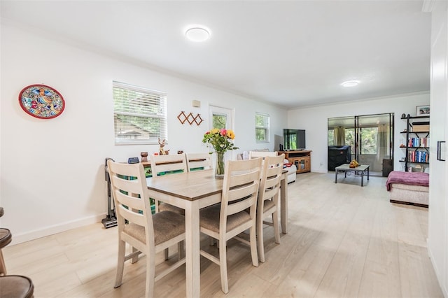 1400 Tarpon Woods Blvd Unit E4, Palm Harbor, FL 34685 - dining area with crown molding, plenty of natural light, light wood-style flooring, and baseboards