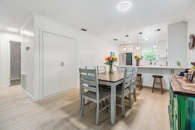 1400 Tarpon Woods Blvd Unit E4, Palm Harbor, FL 34685 - dining area with light wood finished floors, recessed lighting, and ornamental molding