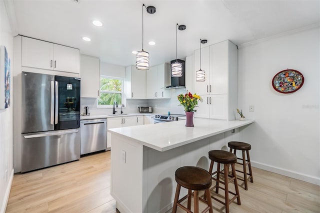 1400 Tarpon Woods Blvd Unit E4, Palm Harbor, FL 34685 - kitchen featuring stainless steel appliances, a peninsula, light wood-type flooring, tasteful backsplash, and a breakfast bar