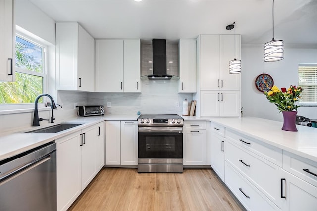 1400 Tarpon Woods Blvd Unit E4, Palm Harbor, FL 34685 - kitchen with wall chimney range hood, stainless steel appliances, a sink, and white cabinetry