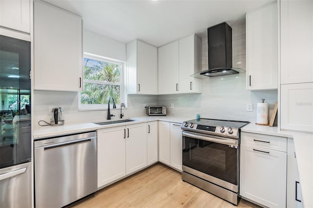 1400 Tarpon Woods Blvd Unit E4, Palm Harbor, FL 34685 - kitchen featuring wall chimney exhaust hood, appliances with stainless steel finishes, a sink, decorative backsplash, and light countertops