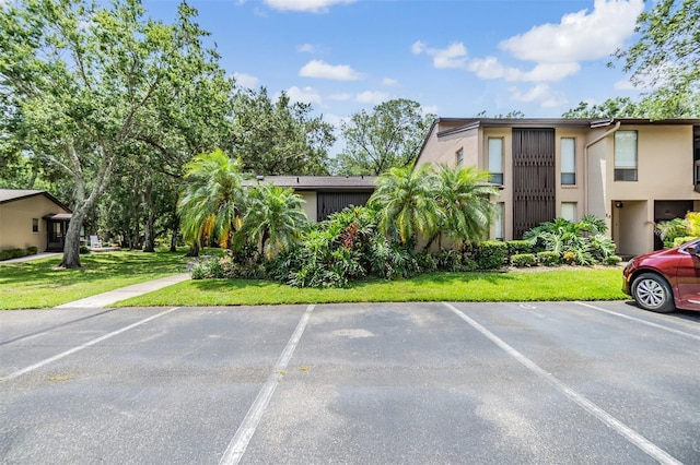 1400 Tarpon Woods Blvd Unit E4, Palm Harbor, FL 34685 - view of front of property featuring uncovered parking, stucco siding, and a front yard