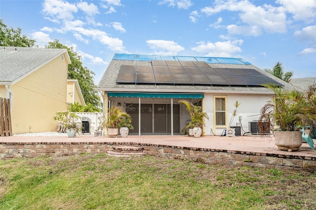 7833 Ontario Street Cir, Sarasota, FL 34243 - rear view of house with a patio, roof mounted solar panels, central AC, and a shingled roof