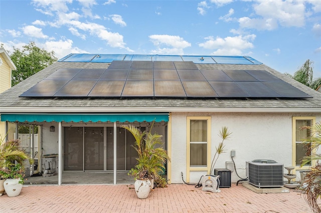 7833 Ontario Street Cir, Sarasota, FL 34243 - back of house with cooling unit, solar panels, stucco siding, and a patio area