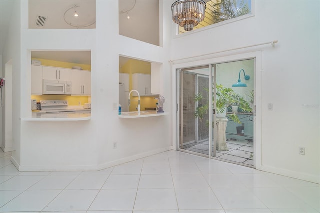7833 Ontario Street Cir, Sarasota, FL 34243 - spare room featuring a chandelier, a towering ceiling, and baseboards