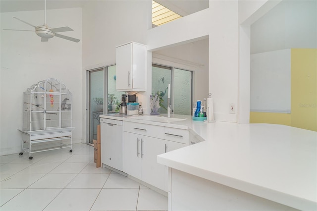 7833 Ontario Street Cir, Sarasota, FL 34243 - kitchen with a sink, white dishwasher, white cabinetry, light countertops, and a towering ceiling