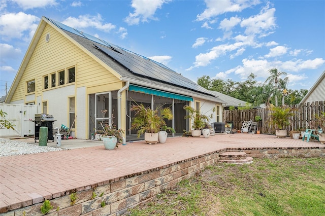 7833 Ontario Street Cir, Sarasota, FL 34243 - rear view of property with a patio area, solar panels, a sunroom, and a fenced backyard