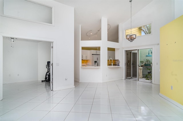 7833 Ontario Street Cir, Sarasota, FL 34243 - empty room with high vaulted ceiling, tile patterned flooring, and a chandelier
